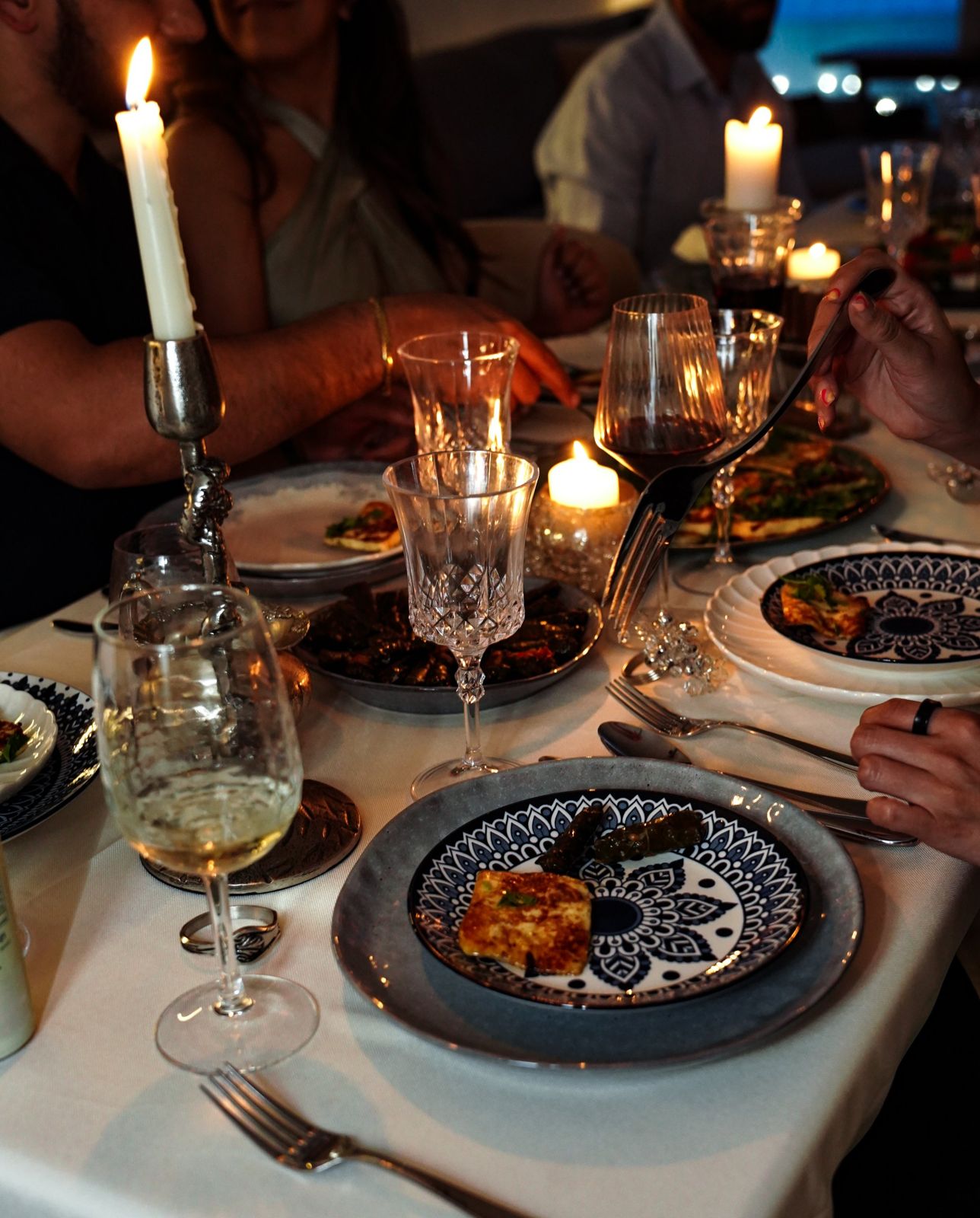 Guests gathered in candlelight around a set table